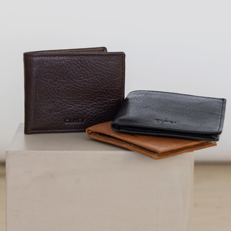 Three leather wallets in brown, black, and Cognac on a light gray surface with a white background.