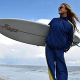 A woman wearing a blue and yellow surf suit 