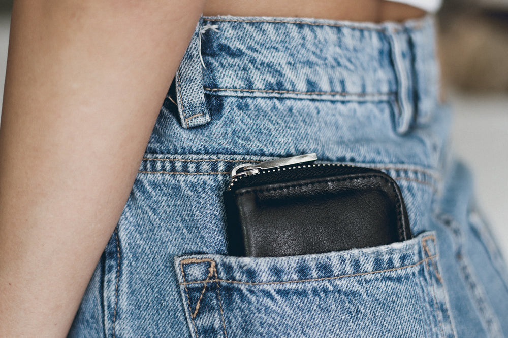 Mini Wallet in Black leather in pocket of model's jeans
